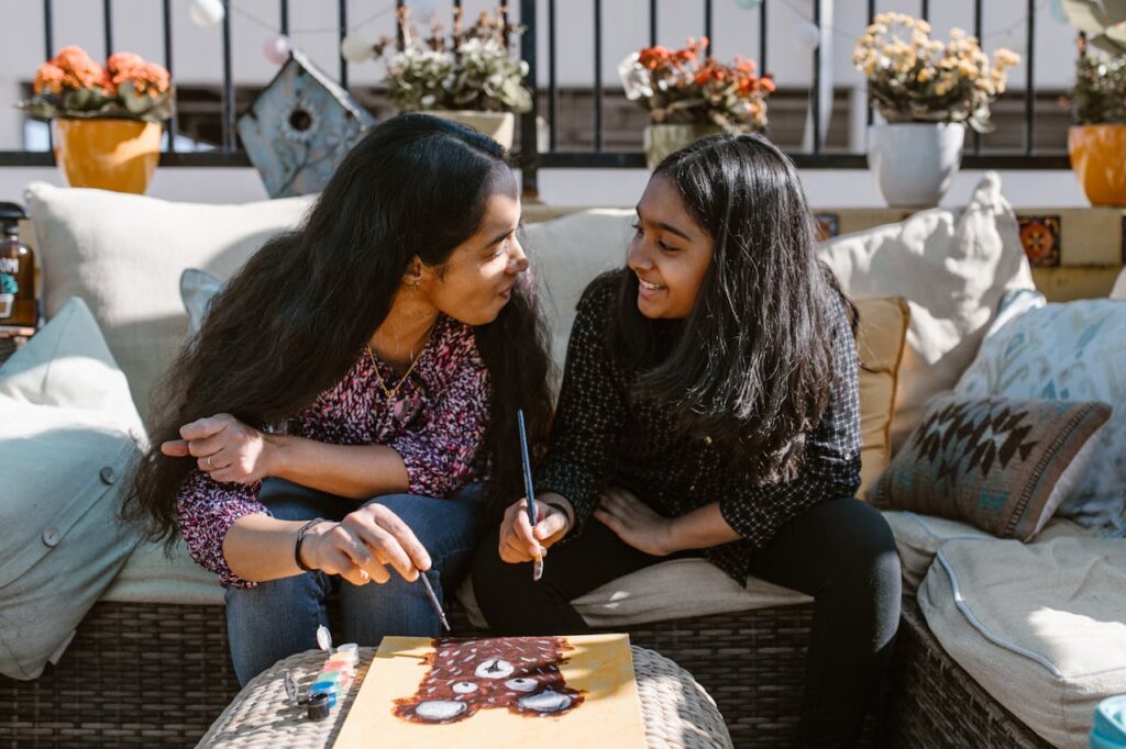 A mother and daughter enjoy a creative art session together outdoors.